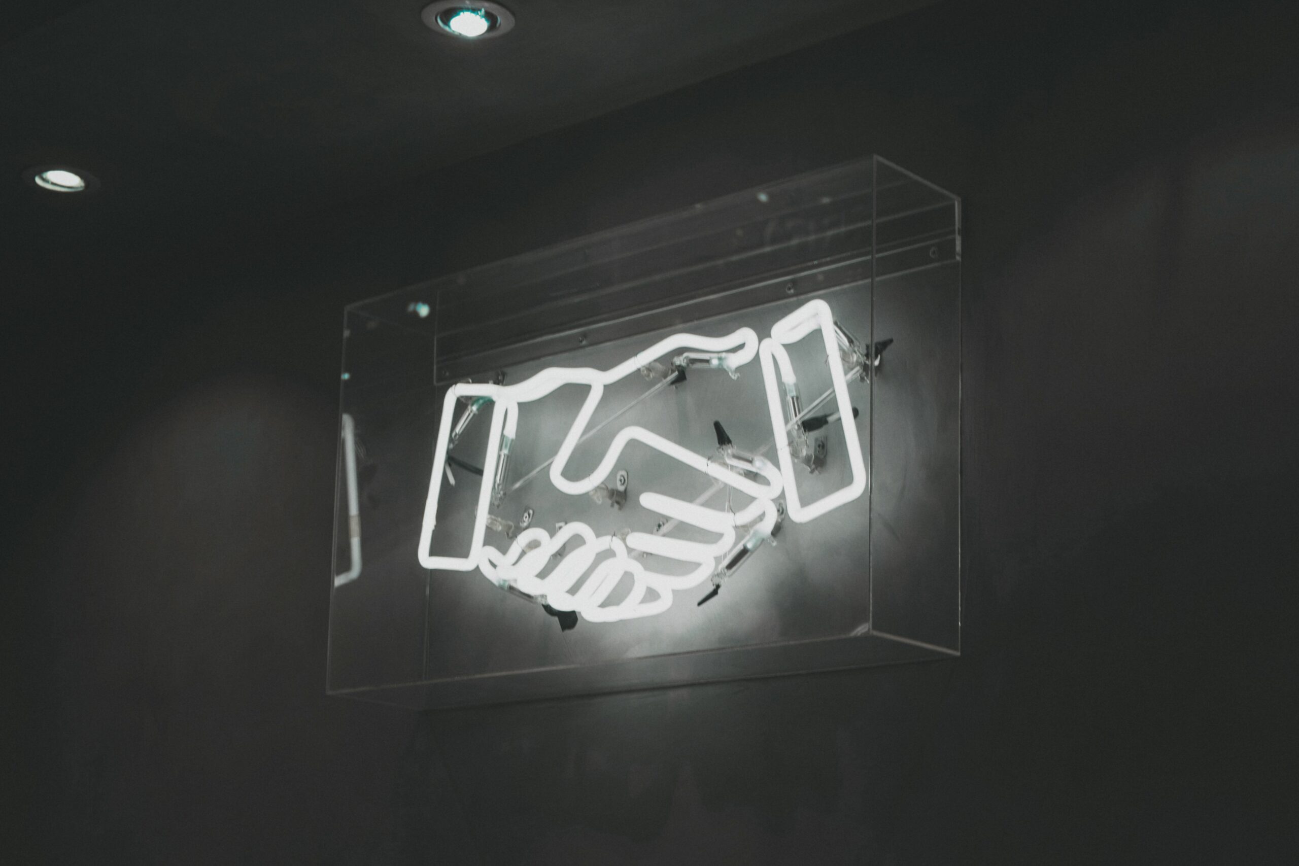 photo - a shining wall sign of two shaking hands black and white